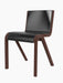 A three-quarter view of the Ready Dining Chair, Front Upholstered, featuring a red-stained oak frame and black upholstery.