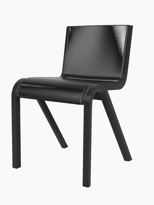 Angled view of the Ready Dining Chair. It has a black oak frame with visible grain and a seat upholstered in black leather.