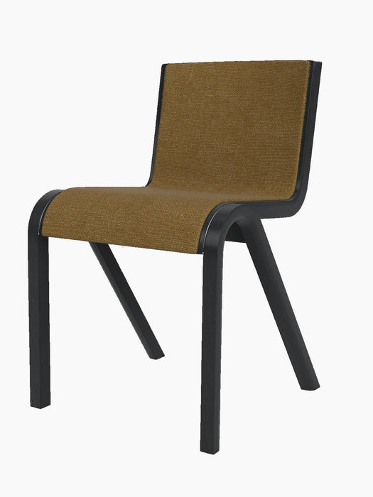 A Ready Dining Chair with front upholstery in golden-brown bouclé. The cantilevered frame is made of black painted oak.