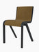 A Ready Dining Chair with front upholstery in golden-brown bouclé. The cantilevered frame is made of black painted oak.