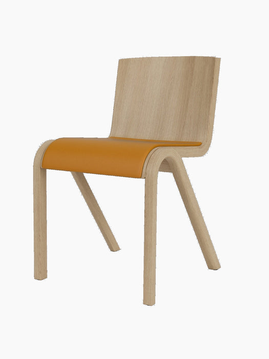 Front three-quarter view of the Ready Dining Chair. It has a natural oak frame and a tan upholstered seat.