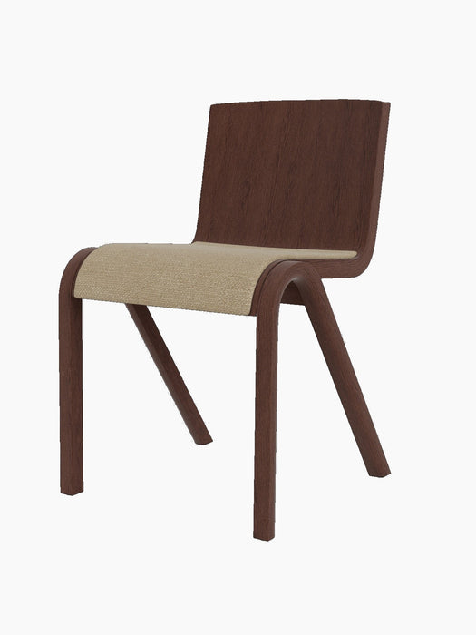 A side view of the Ready Dining Chair with a red-stained oak frame and a seat upholstered in light Audo Bouclé fabric.