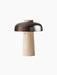 Reverse Table Lamp, Portable with a conical travertine base and a curved, bronzed aluminium shade on a black background.