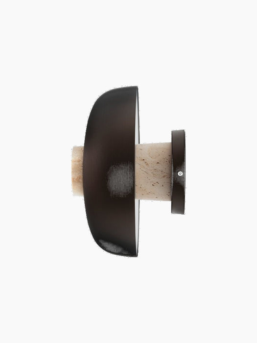 Detail side view of the turned-off Reverse Wall Lamp, showing the bronzed aluminium shade and the travertine stone base.