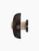 Detail side view of the turned-off Reverse Wall Lamp, showing the bronzed aluminium shade and the travertine stone base.