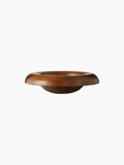 Front-facing view of the sculptural Rond Bowl, crafted from warm-toned wood, with a wide, flared rim on a dark background.