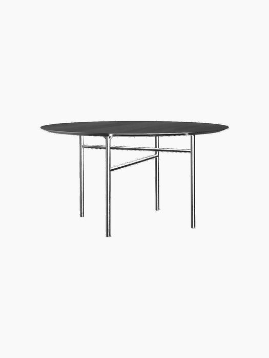 A round, black Snaregade Dining Table with a black oak veneer top and minimalist black steel base, on a black background.