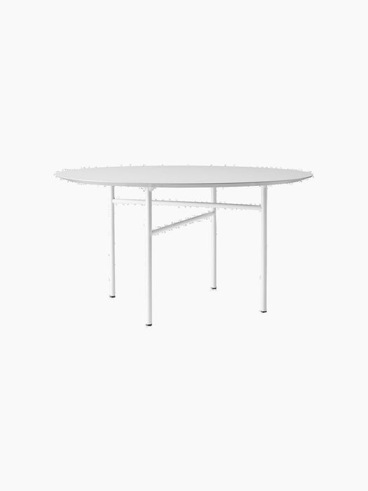 Studio shot of the round Snaregade Dining Table. It has a light grey mushroom linoleum top and a slim, white geometric base.