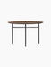 Front view of the Snaregade Dining Table, Round, featuring a dark stained oak top and a minimalist black steel base.