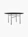 A black, round Snaregade Dining Table with a minimalist design, featuring a thin top and a geometric base of slender legs.