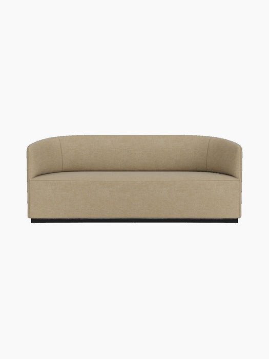 A front-on studio shot of the Tearoom Sofa upholstered in light beige Audo Bouclé 02, featuring its curved back and arms.