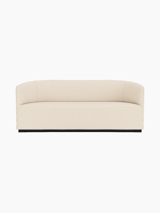 Front view of the Tearoom Sofa in a light-coloured Logan Jasmine fabric, featuring a curved back and arms on a dark base.