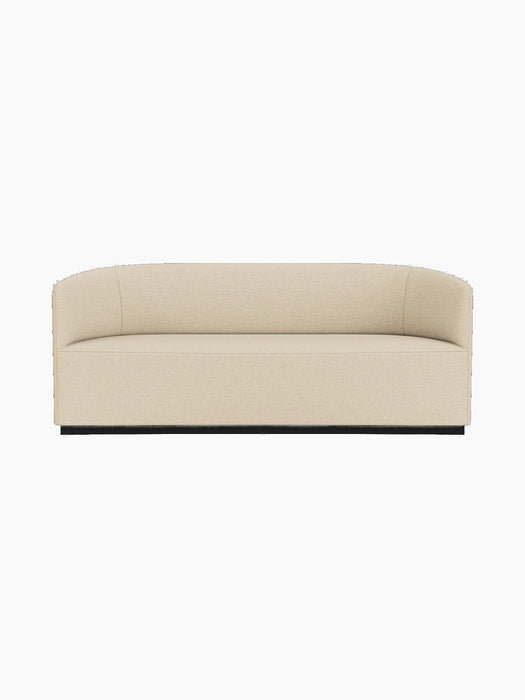 A front-on photograph of the Tearoom Sofa upholstered in a light beige Logan Sand fabric, set against a black background.