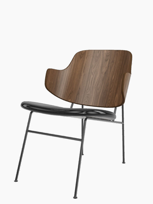 The Penguin Lounge Chair with a curved walnut veneer backrest and a black leather seat on a black powder-coated steel frame.