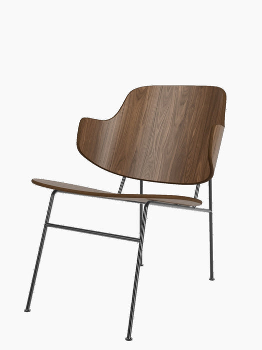Side view of The Penguin Lounge Chair with a sculptural back and seat in walnut veneer, on a slim, black steel frame.