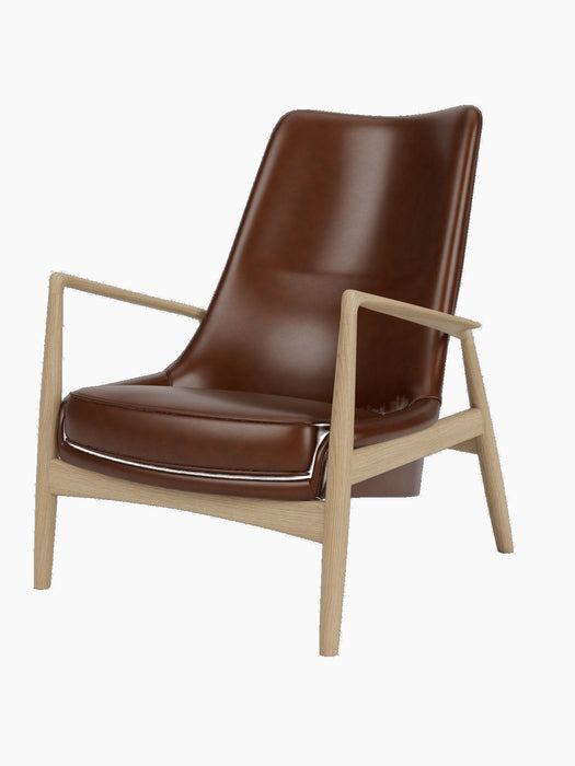 Studio shot of The Seal Lounge Chair, High Back. The chair has a natural oak frame and is upholstered in dark brown leather.