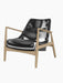 The Seal Lounge Chair, Low Back, shown at a three-quarter angle, featuring a natural oak frame and black leather upholstery.