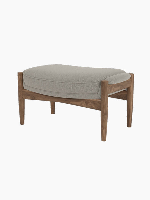 A studio shot of The Seal Ottoman, showing its oiled walnut frame and light grey Re-Wool 218 upholstered cushion.