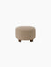 A back view of The Tired Man Ottoman, upholstered in a light brown textile, standing on four short, dark-stained oak legs.