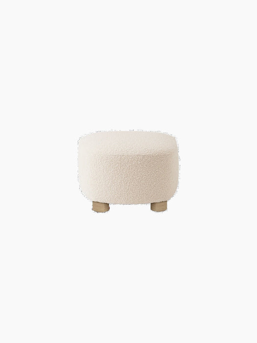Back view of The Tired Man Ottoman, upholstered in an off-white textured textile with four short, natural oak legs.