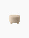The Tired Man Ottoman, seen from the back, upholstered in a cream textured fabric with four short, stout light oak legs.