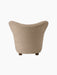 Back view of The Tired Man Lounge Chair upholstered in a textured beige textile, showing its curved back and dark oak legs.