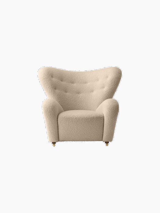Front view of The Tired Man Lounge Chair in a cream textured fabric, with a high, curved back and button tufting.