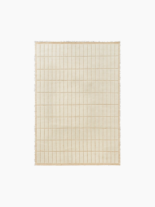 Top-down view of a square, cream-coloured rug featuring a grid pattern of raised rectangular tiles with a textured border.