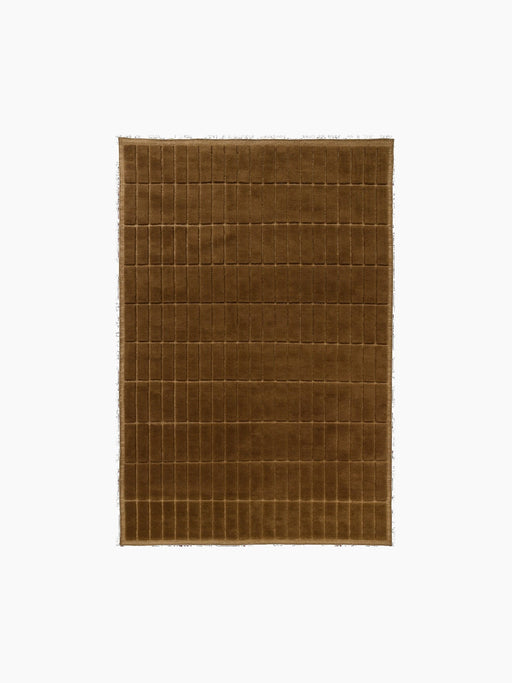 Top-down view of a square, plush rug in a warm brown colour, featuring a carved grid pattern of small, uniform rectangles.