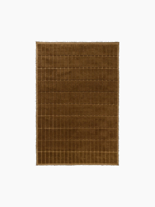 Top-down view of a square, plush rug in a warm brown colour, featuring a carved grid pattern of small, uniform rectangles.