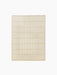 Top-down view of a square, light beige rug featuring a raised grid pattern of soft, rectangular tiles and a woven border.