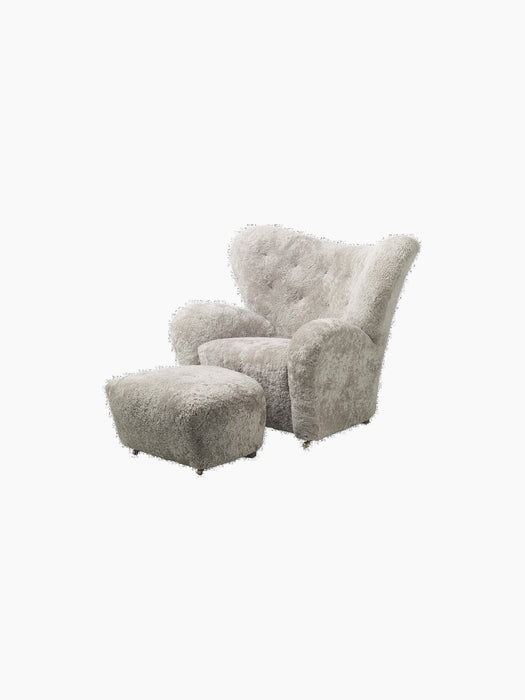 The Tired Man Ottoman, shown with the matching armchair. Both are upholstered in plush, green-tea coloured sheepskin.