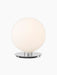 Front view of the TR Bulb Ceiling/Wall Lamp with its illuminated spherical opal glass shade on a polished steel base.