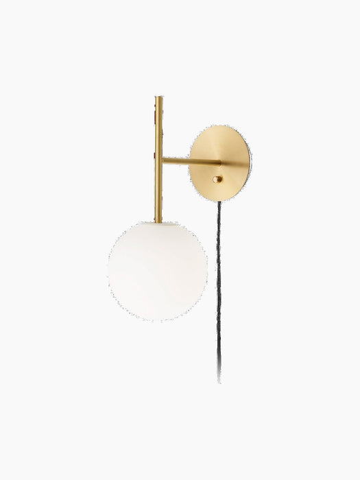 Angled view of the TR Bulb, Suspended Wall Lamp in brushed brass, featuring a glowing spherical white opal glass bulb.