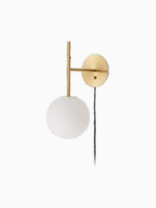 A TR Bulb, Suspended Wall Lamp in brushed brass with a white opal glass globe, shown against a plain black background.