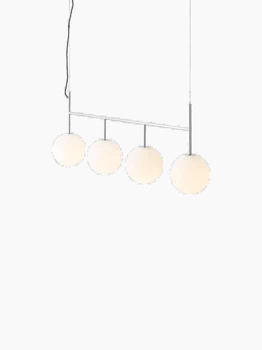 A TR Bulb, Suspension Frame in polished steel with four illuminated spherical opal glass shades, against a black background.