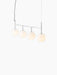 A TR Bulb, Suspension Frame in polished steel with four illuminated spherical opal glass shades, against a black background.