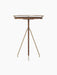 The tall Umanoff Side Table, shown from the front, featuring a solid walnut top with a brushed brass rail and a tripod base.