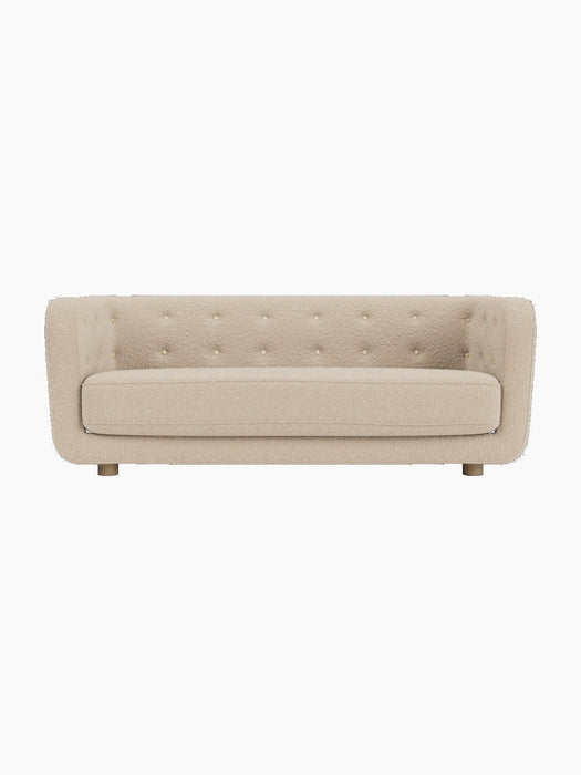 Front view of the Vilhelm Sofa in a light beige textured upholstery, with a button-tufted backrest and natural oak legs.