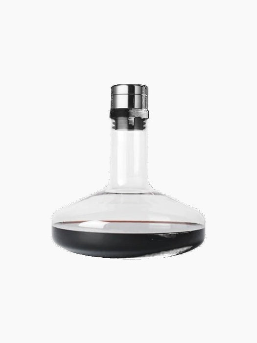 The clear glass Wine Breather Deluxe carafe with a steel stopper and dark base, containing red wine on a black background.