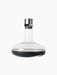 The clear glass Wine Breather Deluxe carafe with a steel stopper and dark base, containing red wine on a black background.