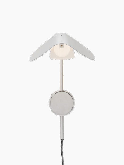 A front view of the illuminated Wing Wall Lamp in polished aluminium, featuring a wing-like shade over a glowing diffuser.