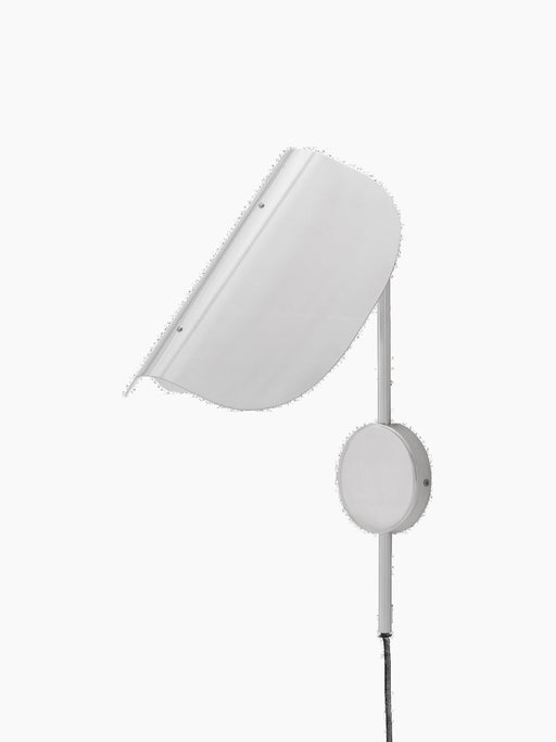 An angled view of the Wing Wall Lamp in polished aluminium. The light is off, showing the curved shade, support arm and cord.