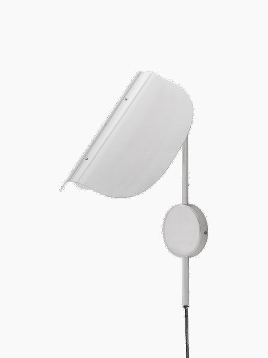 An angled view of the Wing Wall Lamp in polished aluminium. The light is off, showing the curved shade, support arm and cord.